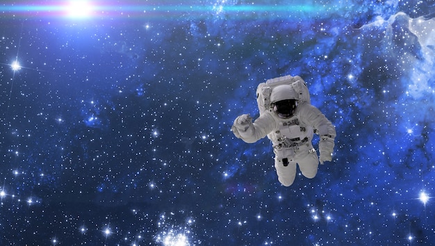 Un cosmonauta vola nello spazio esterno con stelle e sfondo di galassie con un raggio di luce. elementi di questa immagine forniti dalla nasa