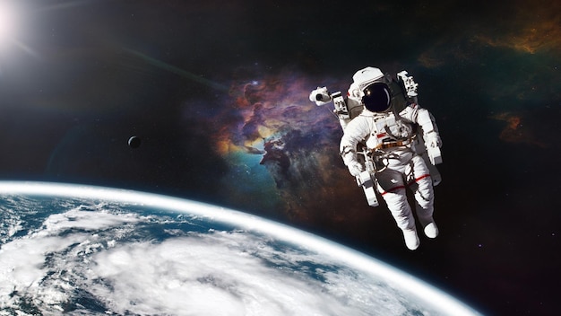 Cosmonaut in outer space against Earth planet Elements of this image furnished by NASA