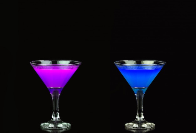 Foto cocktail cosmopolita in un bel viola e blu davanti a un nero