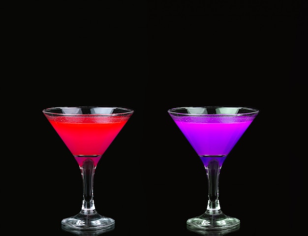 Cocktail cosmopolita in un bel rosso, viola davanti a un nero