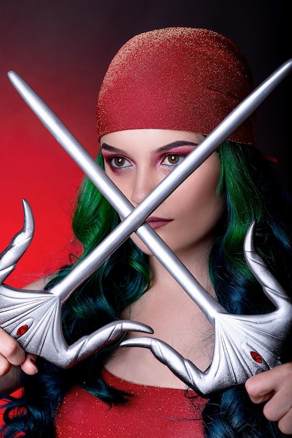 Foto cosplay su elektra dal film daredevil comic con meraviglia ragazza con i capelli verdi in studio su sfondo rossoxa