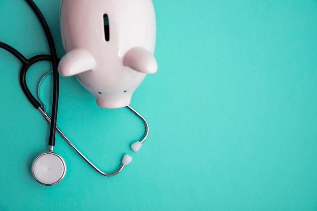 Cost of healthcare piggy bank money box with a medical doctors stethoscope