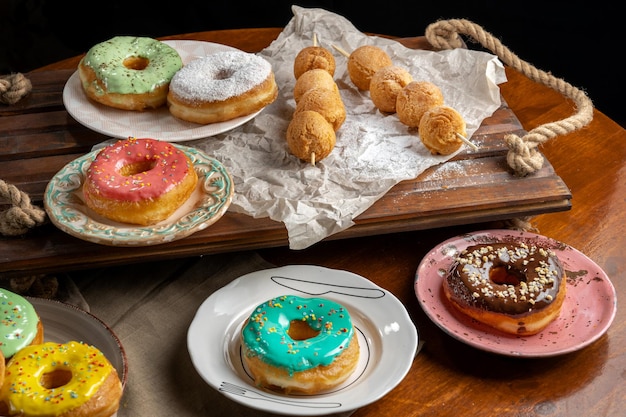 Cottage cheese balls on wooden skewers lie on craft paper with donuts Dusted with icing sugar