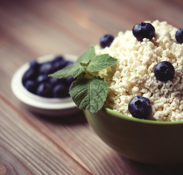 Cottage cheese and blueberry and mint in a bowl on a table