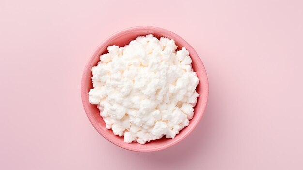 Cottage cheese in a bowl on pink background with copy space