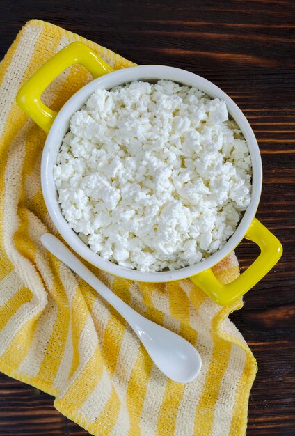 Cottage cheese in a bowl on a wooden table