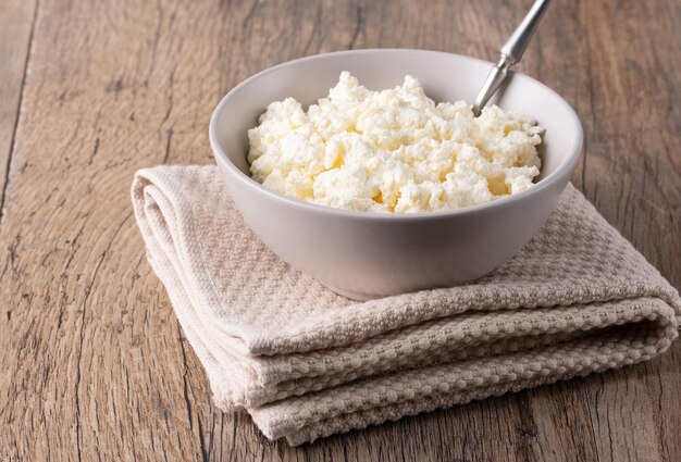 Cottage cheese in a bowl on a wooden table