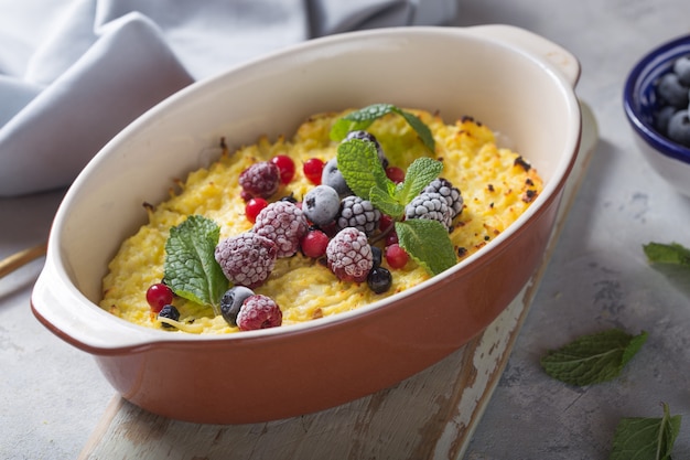 Cottage cheese casserole baked with  with fresh berries on kitchen table.