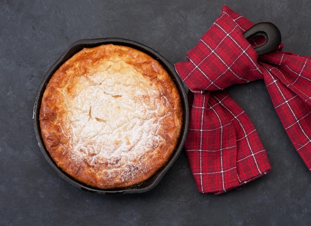 Foto casseruola di ricotta cheesecake su sfondo nero vista dall'alto