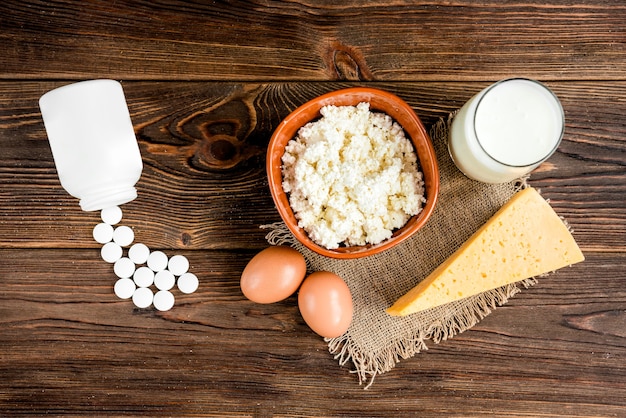 Cottage cheese, cheese and glass of milk on wooden background. Dairy products.