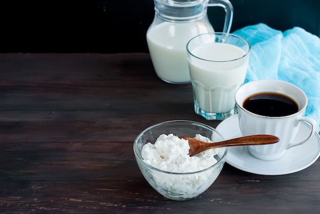 Cottage cheese and  cup of black coffee on a wooden table 