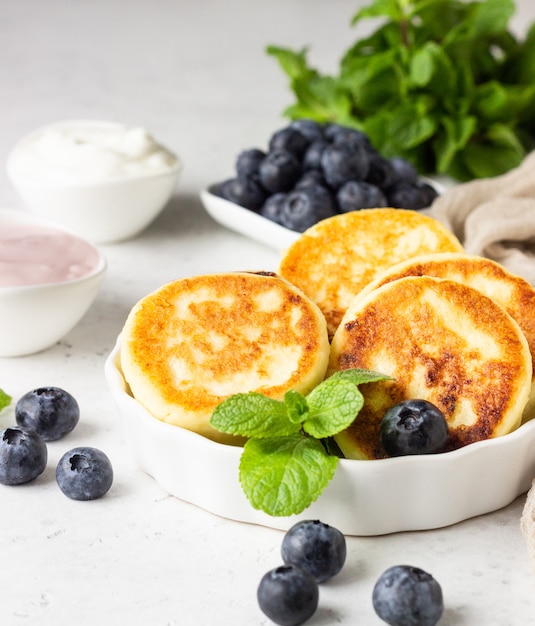 Cottage cheese fritters with blueberries, mint and sauce.