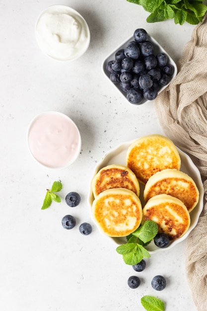 Cottage cheese fritters with blueberries, mint and sauce.