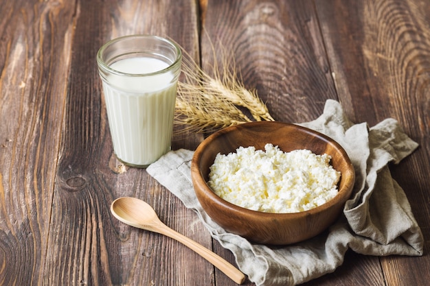 Cottage cheese, milk and ears of wheat on rustic wooden table. Dairy products for jewish holiday Shavuot.