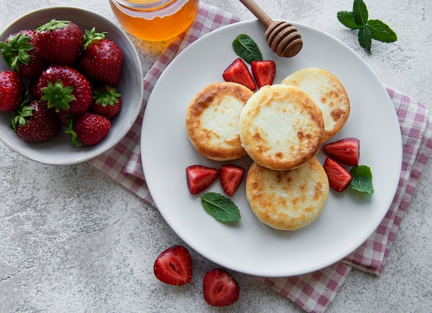 Cottage cheese pancakes ricotta fritters on ceramic plate with  fresh strawberry