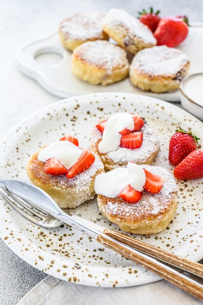 Cottage cheese pancakes, syrniki, curd fritters with strawberry. Gray space. Top view