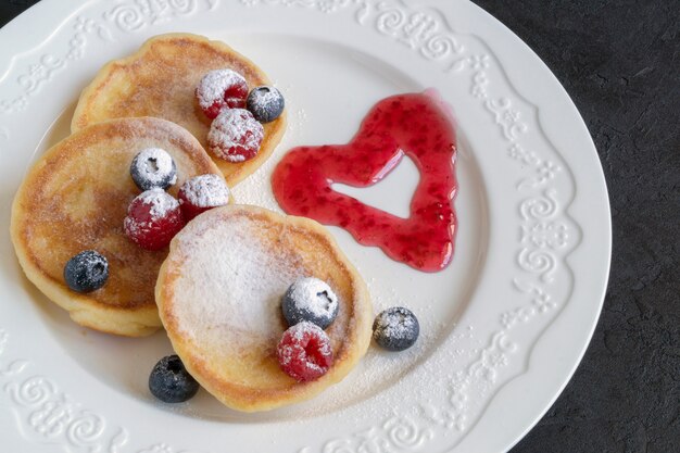 Frittelle di ricotta, syrniki con frutti di bosco freschi.