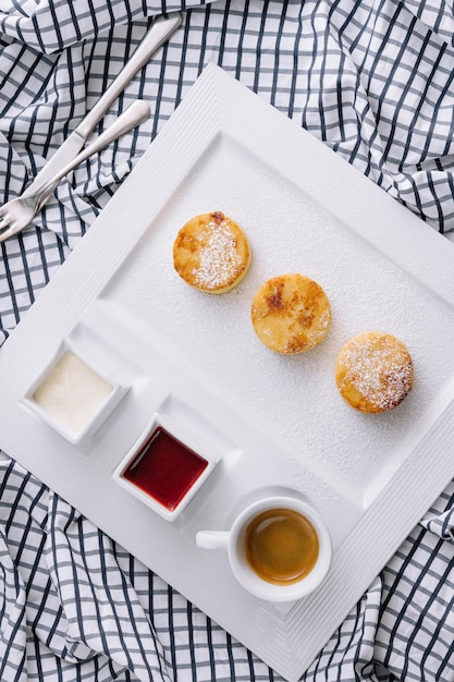 Cottage cheese pancakes with berry sauce and sour cream and coffee