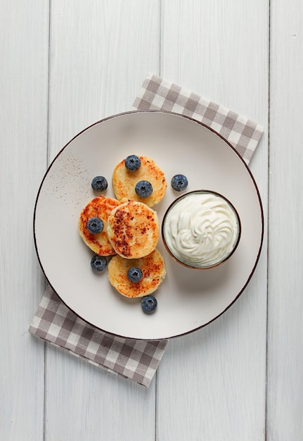 Cottage cheese pancakes with blueberries breakfast on a white wooden table no people top view