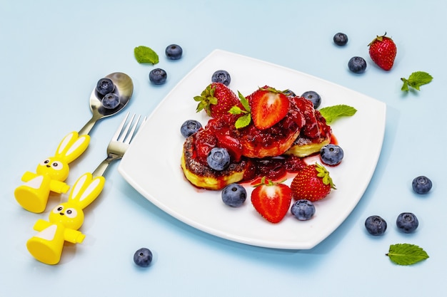 Cottage cheese pancakes with fresh berries and strawberry sauce for kids