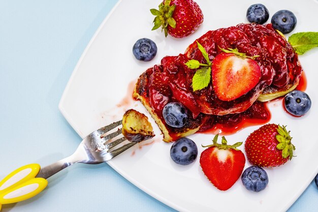 Cottage cheese pancakes with fresh berries and strawberry sauce for kids