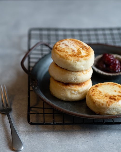 Cottage cheese pancakes with jam, homemade traditional syrniki, selective focus