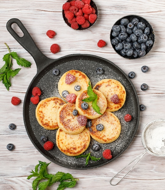 Frittelle di ricotta con lampone e mirtillo in padella su fondo rustico