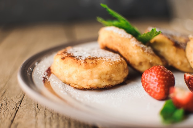 Cottage cheese pancakes with strawberries, mint and icing sugar