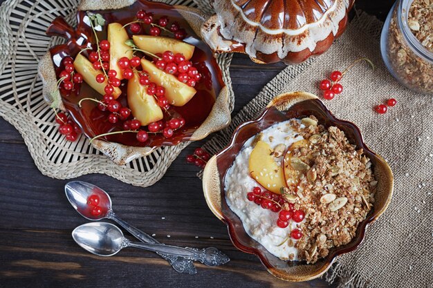 Cottage cheese, red currant and fresh peaches on wooden surface