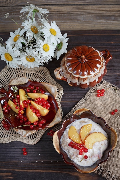 Cottage cheese, red currant and fresh peaches on wooden surface