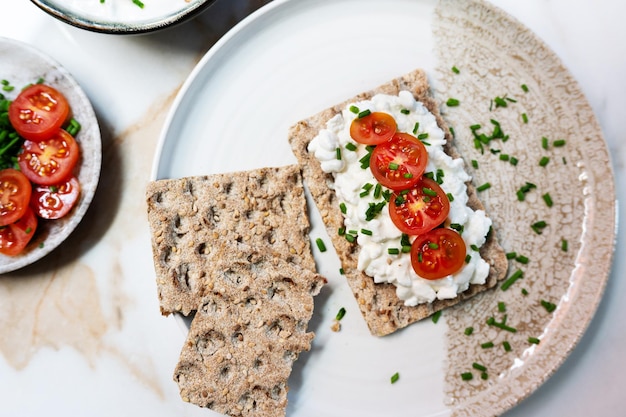 cottage cheese and tomato on crunchy bread served on a plate