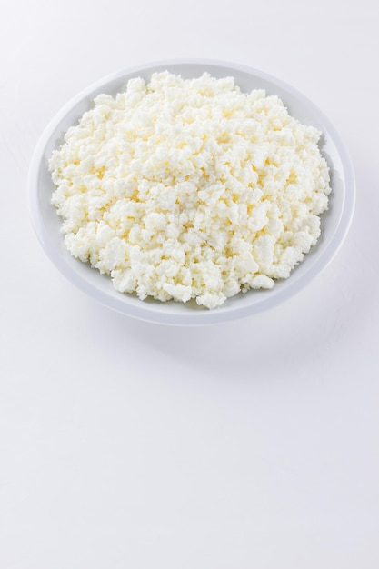 白いプレートにカテージチーズ 白い背景に新鮮なカテジチーズ トップビュー コピースペース