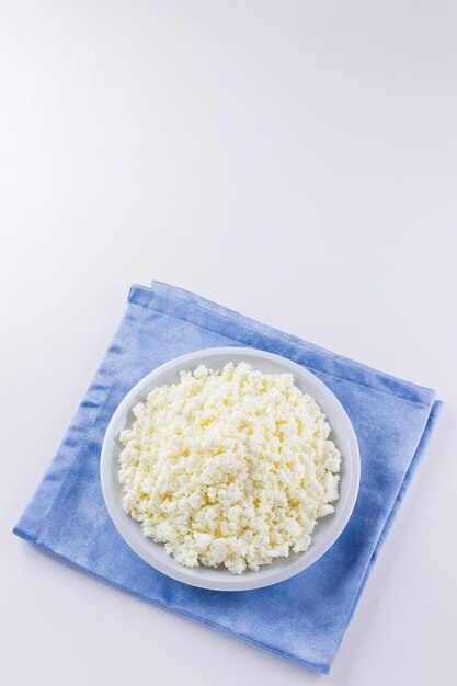 Foto cottage cheese su piatto bianco cottage fresh su sfondo bianco top view copy space