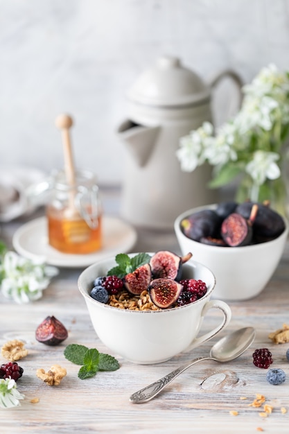 Cottage cheese with figs, berries, honey. Cup of coffee and coffee pot. Breakfast. Wooden table.