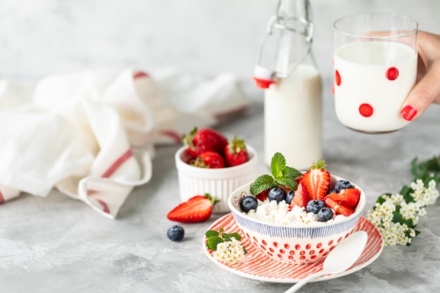 Cottage cheese with fresh strawberries and milk for breakfast.