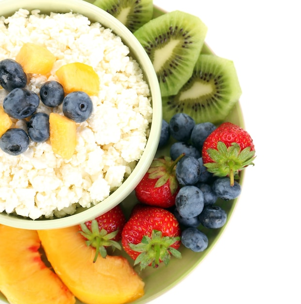 Cottage cheese with fruits and berries in bowl isolated on white