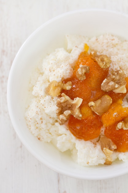 Cottage cheese with pumpkin jam and nuts in bowl