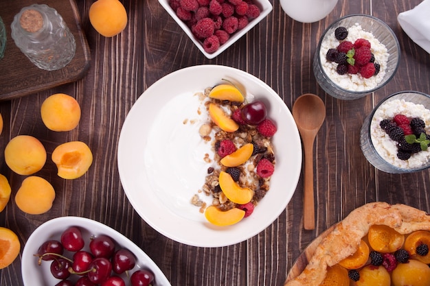 Cottage cheese and yogurt with gronala, berries and fruits apricot for healthy breakfast. Top view.