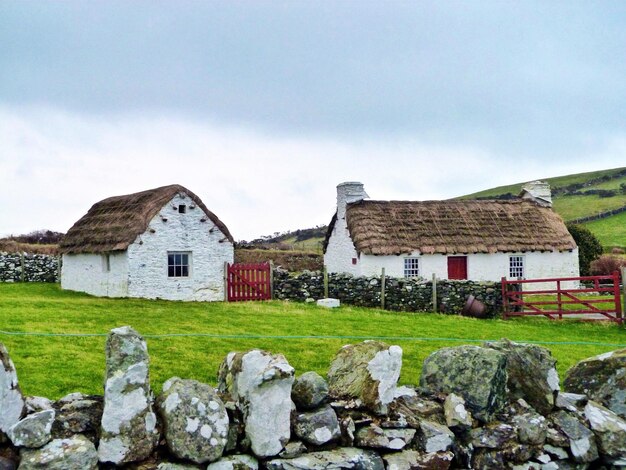 Cottage on field at cregneash against sky