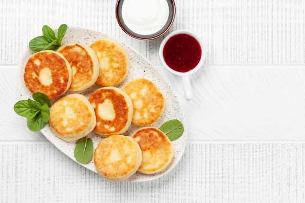 Photo cottage pancakes with jam sour cream