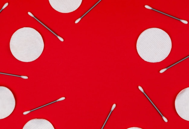 Cotton buds and cotton pads on a red