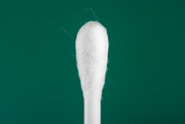 Cotton buds on green background