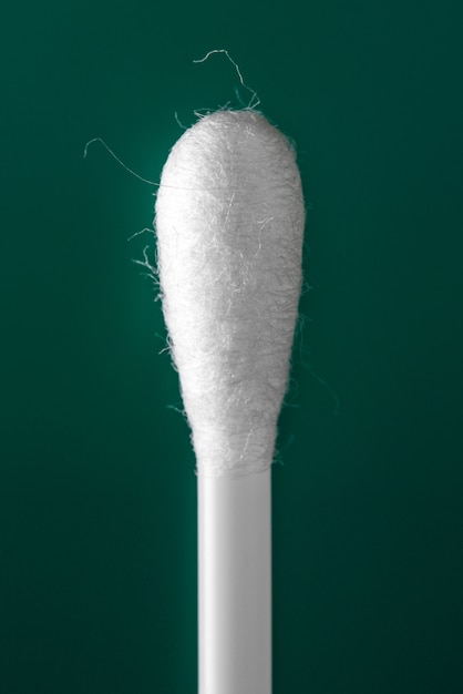 Cotton buds on green background