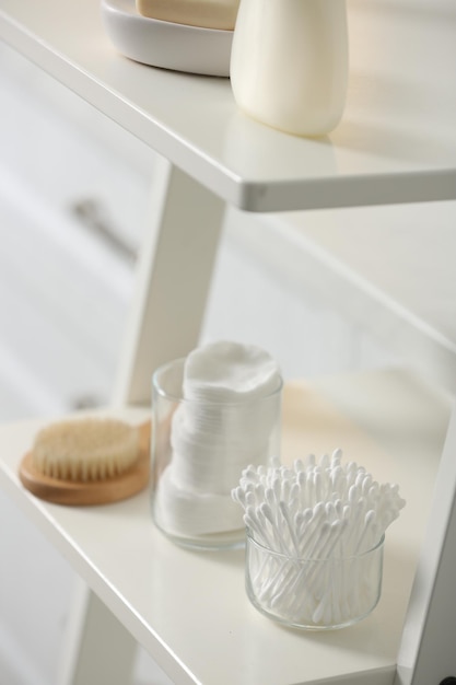 Cotton buds on white rack in bathroom
