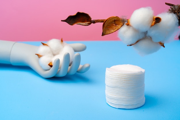 Cotton discs stack on blue paper surface