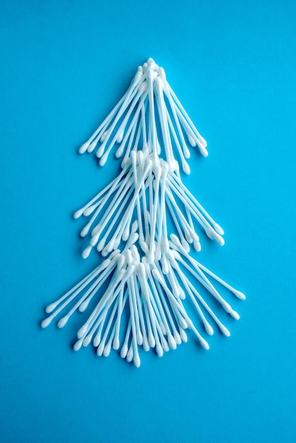 Cotton ear swabs sticks on blue background close up Image with selective focus noise effect and toning Top view Flat lay