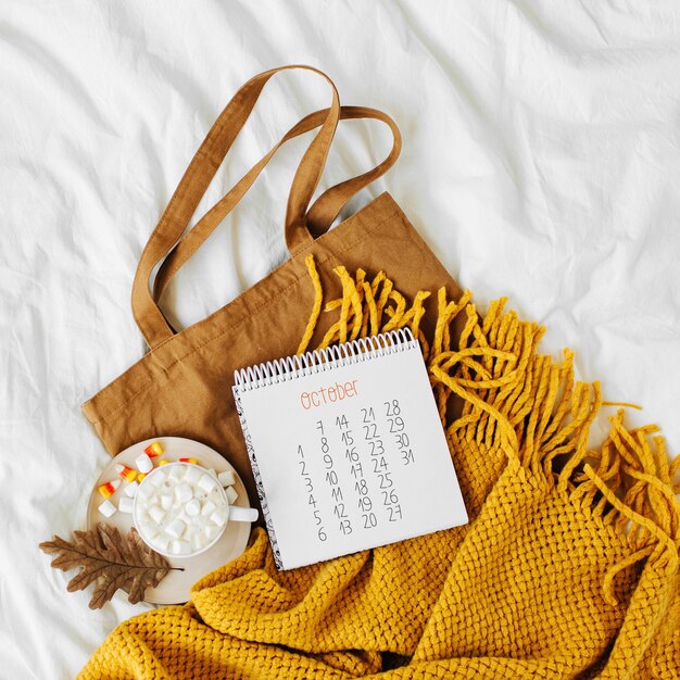 Cotton eco bag with cup of coffee and notebook on bed. autumn
concept.