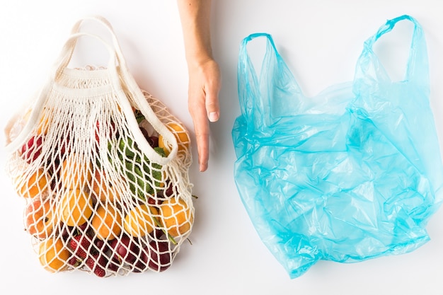 Foto borsa in rete di cotone eco con frutta biologica di stagione su sfondo bianco. concetto ecologico