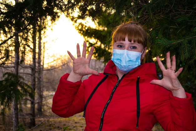 綿生地のフェイスマスクは、コロナウイルスの口カバーを身に着けているヨーロッパの女性の肌を呼吸します...