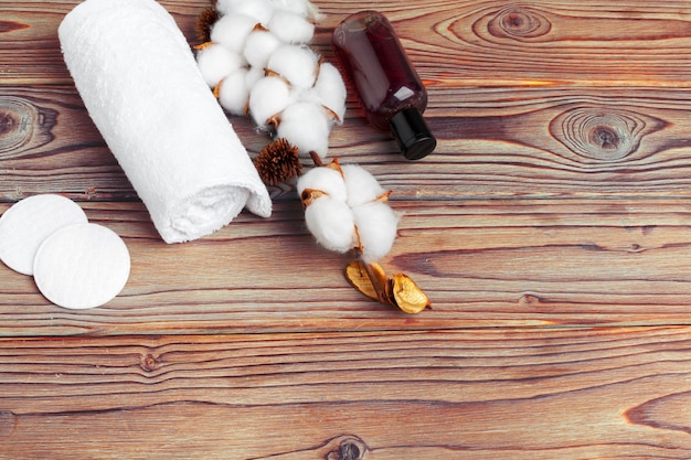 Cotton flowers with towel on wooden table